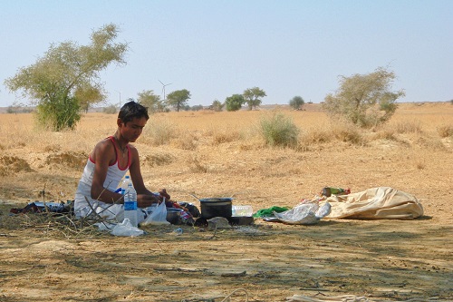 Boy cooking on open fire in Thar Desert near Jaisalmer, India