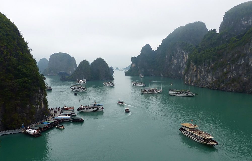 Cruise boats and limestone karst seen from Sung Sot Cave in Halong Bay, Vietnam
