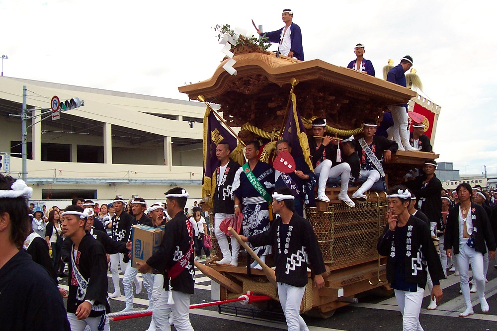 Men in traditional happi coats pulling wooden float at Kishiwada Danjiri in Osaka, Japan