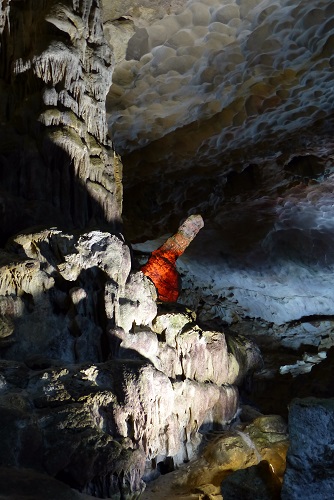 Phallic rock glowing red at Sung Sot Cave in Halong Bay, Vietnam