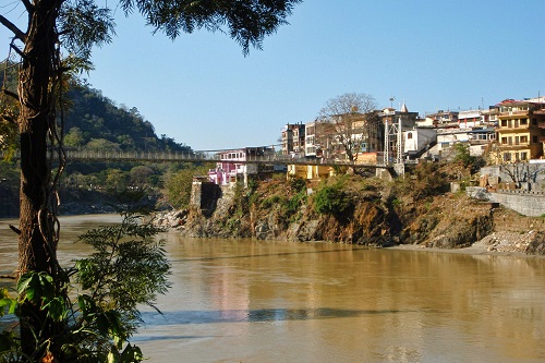 Lakshman Jhula bridge crossing muddy Ganges river in Rishikesh, India