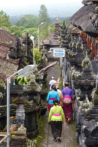 Worshippers walking a narrow path between temples at Pura Besakih temple in Bali, Indonesia