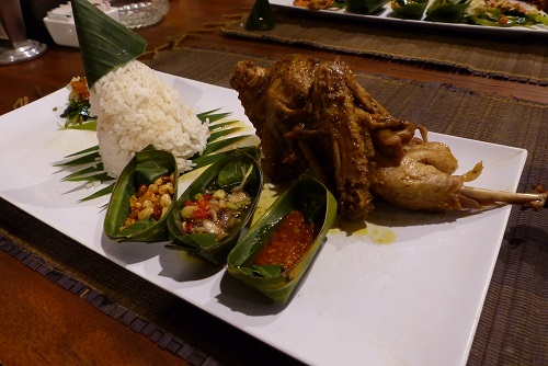 Bebek Betutu duck with sambal side dishes ready to eat in Bali, Indonesia