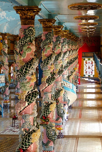 Dragons coiled around columns inside Cao Dai Holy See temple in Vietnam