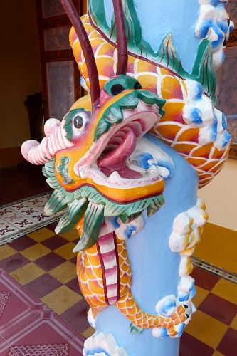 Dragon coiled around a pillar at Cao Dai Holy See temple in Vietnam