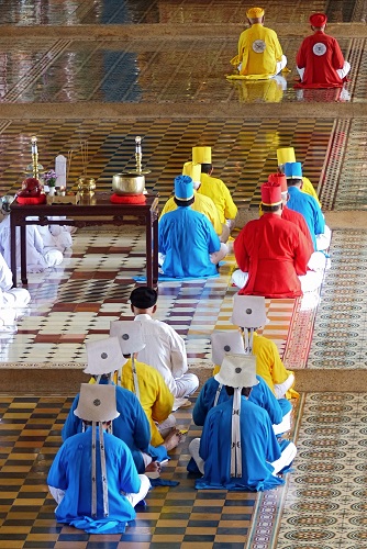 Priests in coloured robes at Cao Dai Holy See temple in Vietnam