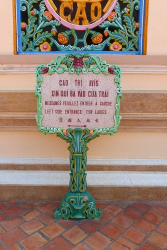 Sign to ladies entrance at Cao Dai Holy See temple in Vietnam