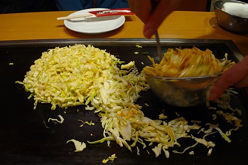 Mixing and grilling okonomiyaki, Osaka food in Japan