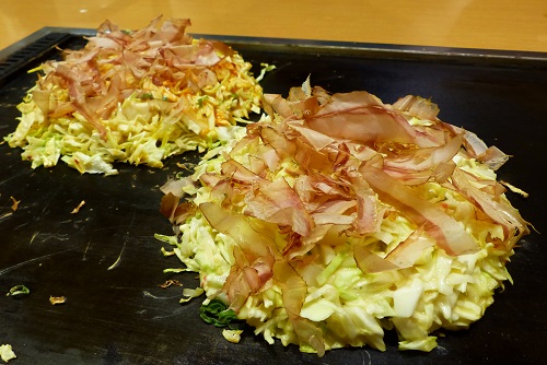 Okonomiyaki food on a grill in Osaka, Japan