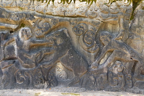 Rock carvings of a boar hunt at Yeh Pulu in Bali, Indonesia