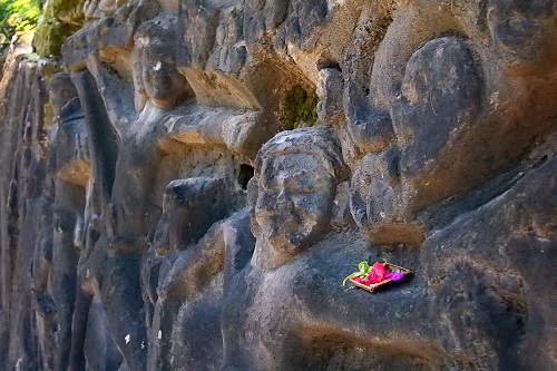 Flower offering on rock carvings at Yeh Pulu in Bali, Indonesia