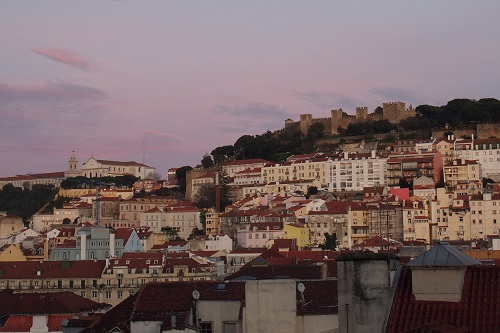 View of city and Sao Jorge Castle from rooftop bar in Lisbon, Portugal