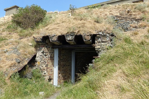 Entrance to WWI tunnel in grassy hillside at Inchcolm Island, Scotland