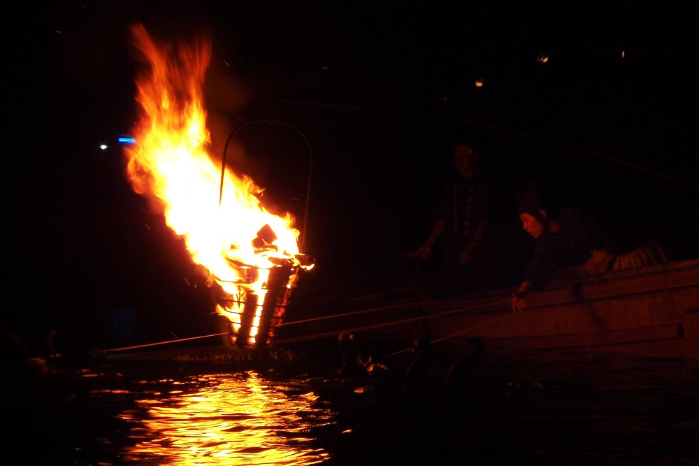 Ukai cormorants on leads fishing from a boat on the Uji River in Japan